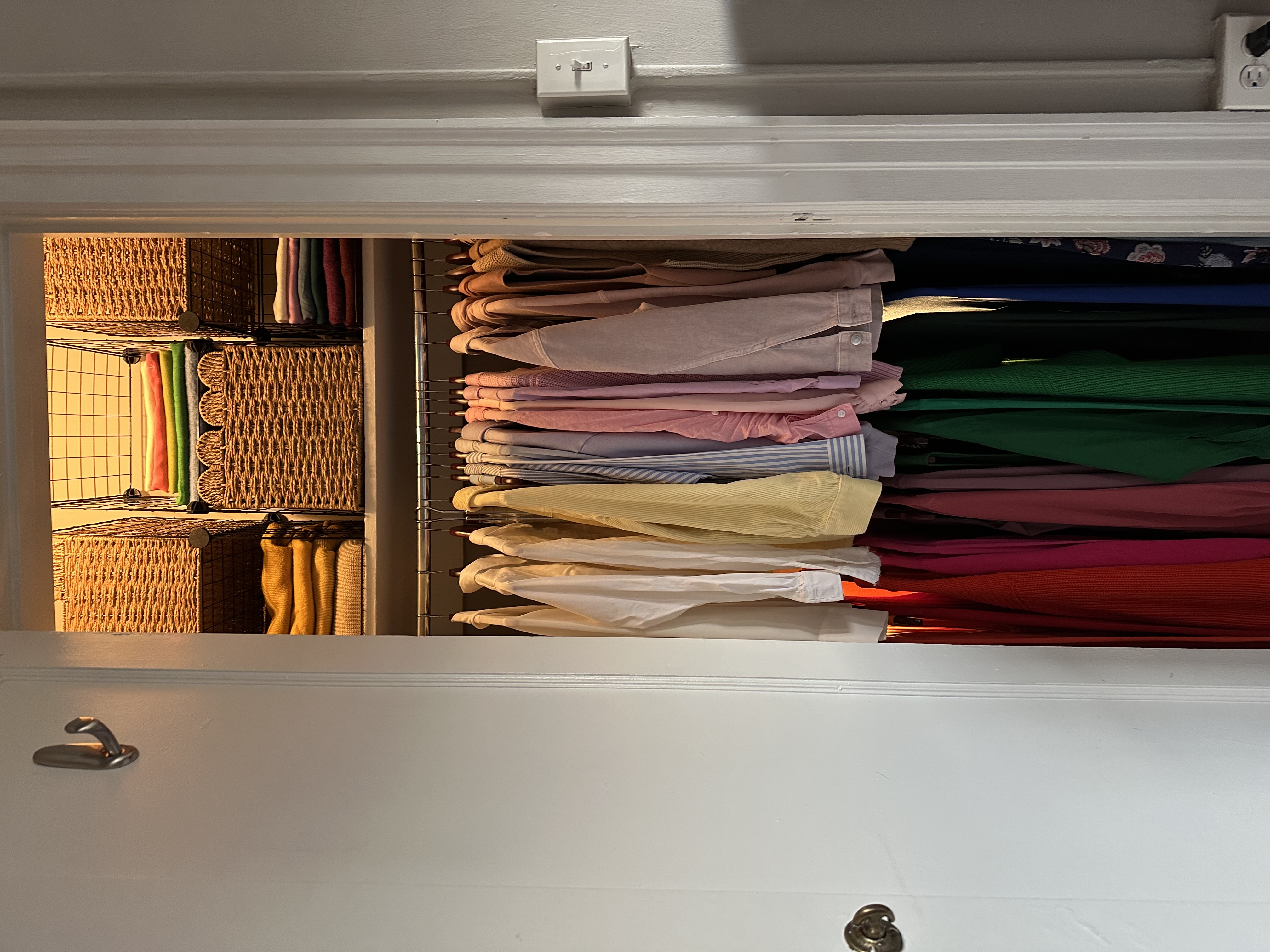 Reach-in closet organized with The Square Inch Method — color-coded hanging clothes and woven baskets
